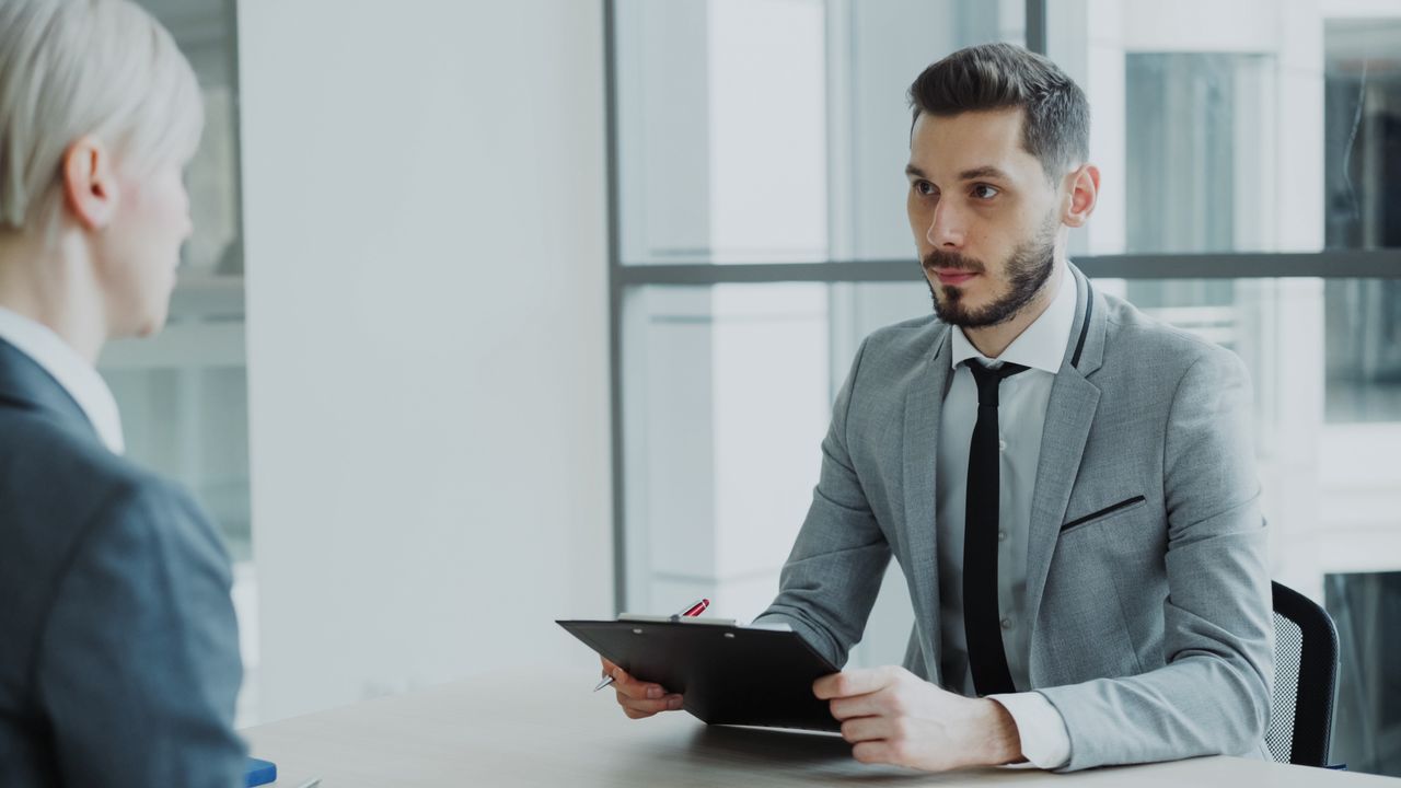 The Art of Drawing Readers In: Your attractive post title goes here Two business professionals engaged in a meeting in a modern office environment.