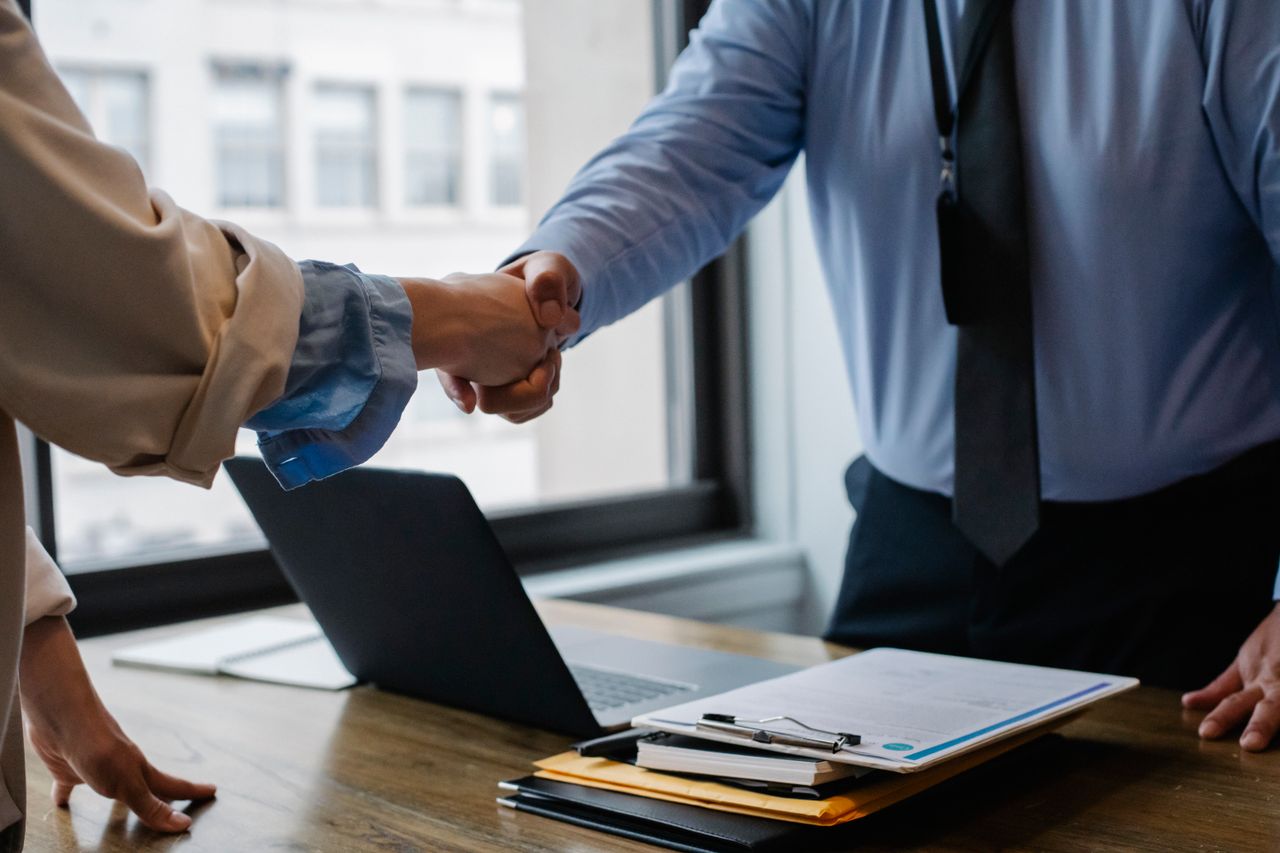 Crafting Captivating Headlines: Your awesome post title goes here Crop unrecognizable coworkers in formal wear standing at table with laptop and documents while greeting each other before meeting